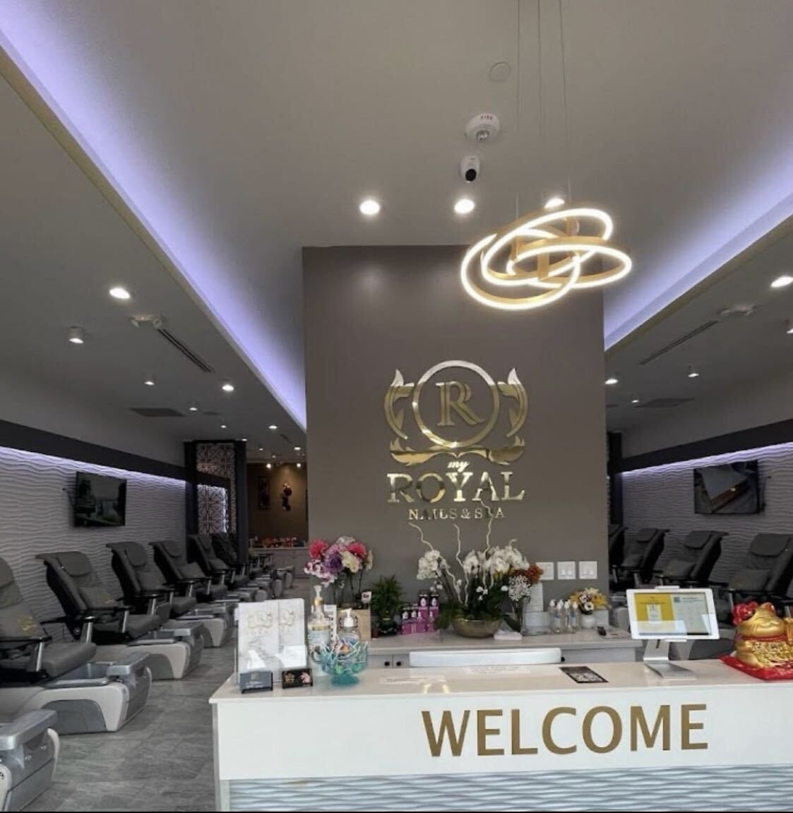 Reception area with ROYAL logo wall and pedicure chairs at My Royal Nails & Spa in Humble, TX