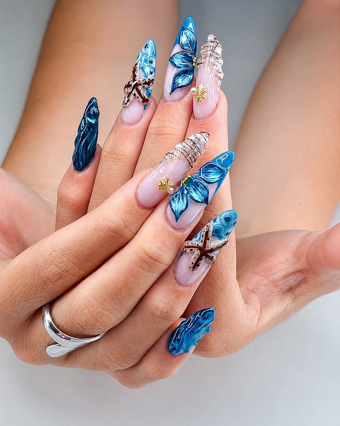 Sky blue nails with 3D butterfly and pearl details by My Royal Nails & Spa in Humble, TX