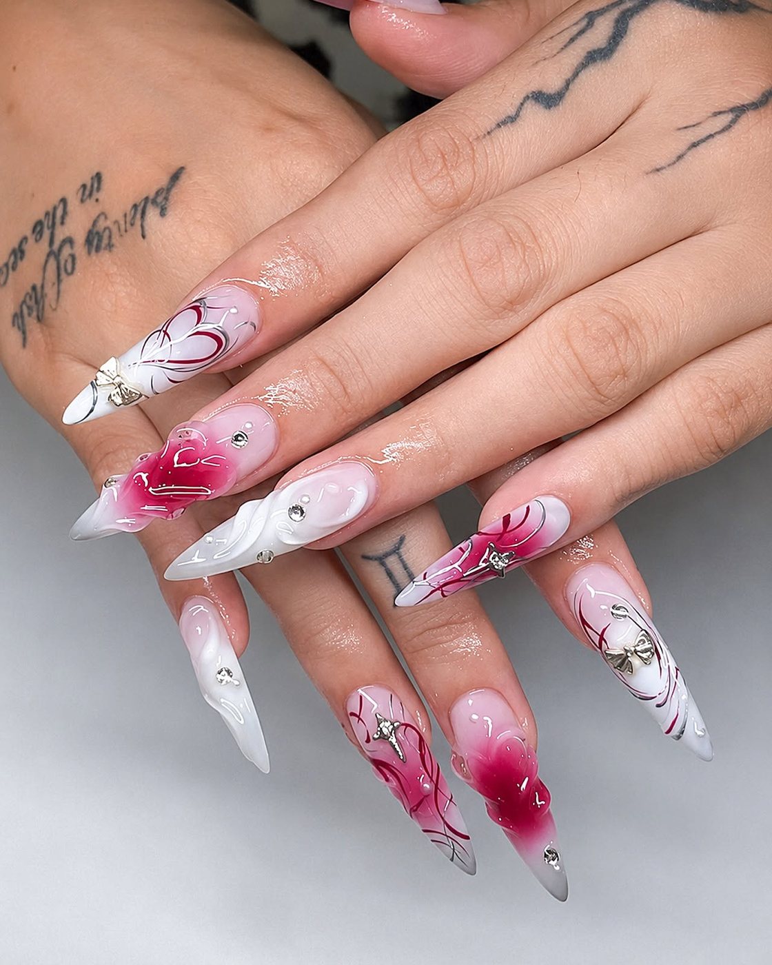 Pink marble nails with hand-painted hearts by My Royal Nails & Spa in Humble, TX